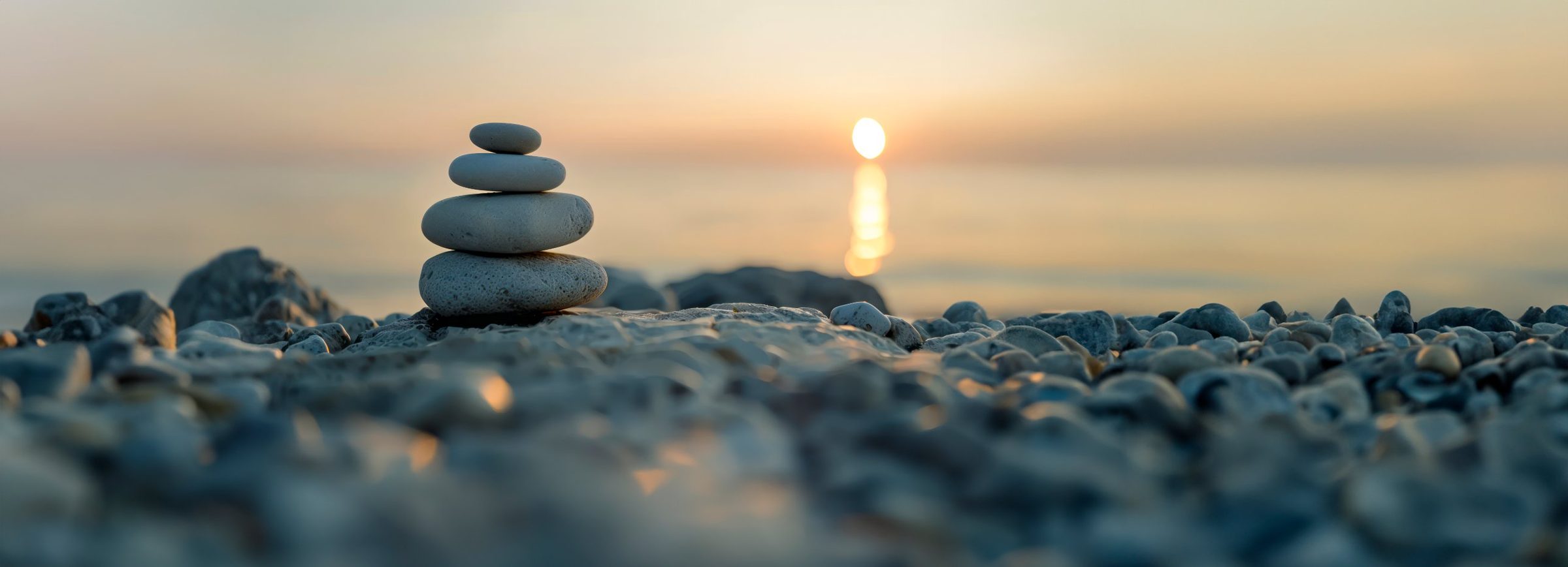 Piedras apiladas en la orilla al atardecer